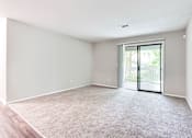 Thumbnail 35 of 81 - an empty living room with a door to a balcony at Magnolia Place at Stockbridge Apartments, Stockbridge, 30281