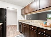 Thumbnail 38 of 81 - a kitchen with wooden cabinets and black refrigerator at Magnolia Place at Stockbridge Apartments, Stockbridge, 30281