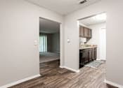 Thumbnail 39 of 81 - an open kitchen and living room with a door to a hallway at Magnolia Place at Stockbridge Apartments, Georgia