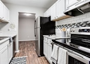 Thumbnail 69 of 81 - a kitchen with white cabinets and stainless appliances at Magnolia Place at Stockbridge Apartments, Georgia