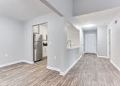 Thumbnail 45 of 81 - a renovated living room with a kitchen with a stainless steel refrigerator at Magnolia Place at Stockbridge Apartments, Stockbridge