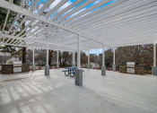 Thumbnail 35 of 37 - a covered patio with a table and a bench under a white roof  at The Sapphire, Decatur, GA