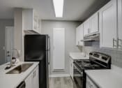 Thumbnail 1 of 37 - a kitchen with white cabinets and black appliances at The Sapphire, Decatur, Georgia