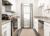 Thumbnail 3 of 37 - a kitchen with stainless steel appliances and white cabinets at The Sapphire, Decatur, Georgia