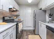 Thumbnail 4 of 37 - a white kitchen with stainless steel appliances and white cabinets at The Sapphire, Decatur, Georgia
