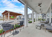 Thumbnail 27 of 39 - a patio with couches and tables and large windows at Century Mundy Mill Apartments, Georgia