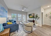 Thumbnail 2 of 39 - a living room with a couch and a chair and a ceiling fan at Century Mundy Mill Apartments, Oakwood