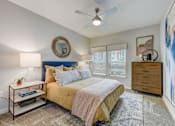 Thumbnail 6 of 39 - a bedroom with a bed and a ceiling fan at Century Mundy Mill Apartments, Oakwood, GA
