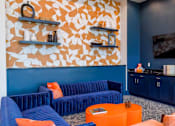 Thumbnail 21 of 36 - A living room with blue and orange furniture and a TV.