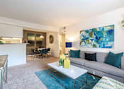 Thumbnail 10 of 18 - A living room with a grey couch, a white coffee table, and a blue rug. at Grove at St. Andrews, Columbia