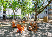 Thumbnail 26 of 31 - A sunny day at the park with chairs and tables.