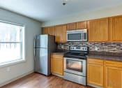 Thumbnail 6 of 20 - a kitchen with stainless steel appliances and wooden cabinets