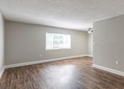 Thumbnail 32 of 34 - an empty living room with hardwood floors and a large window at Summit Augusta, Augusta Georgia