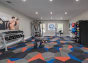 Thumbnail 20 of 31 - A gym with a variety of equipment including dumbbells, weight plates, and a bench press.