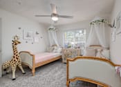 Thumbnail 21 of 31 - A room with two beds and a giraffe toy.