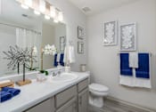 Thumbnail 31 of 31 - A bathroom with a white sink and a toilet.