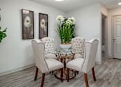 Thumbnail 16 of 31 - A dining room with a glass table and white chairs.