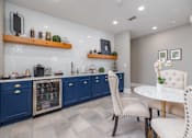 Thumbnail 28 of 31 - A kitchen with blue cabinets and a white table.