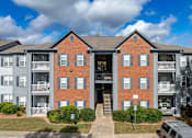 Thumbnail 14 of 31 - A large red brick building with a balcony on the second floor.