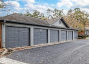 Thumbnail 12 of 31 - A two-car garage with a brick wall and a gabled roof.