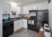 Thumbnail 17 of 27 - a kitchen with white cabinets and black appliances
