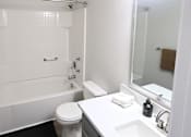 Thumbnail 7 of 21 - A white bathroom with a toilet, sink, and tub.