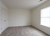 Thumbnail 25 of 30 - a bedroom with white walls and carpet