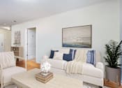Thumbnail 4 of 31 - a living room with a white couch and a coffee table