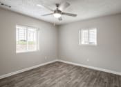 Thumbnail 13 of 34 - A room with a ceiling fan and two windows.
