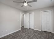 Thumbnail 15 of 34 - A room with a ceiling fan and three doors.