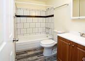 Thumbnail 17 of 30 - A bathroom with a white toilet, a white sink, and a white bathtub.