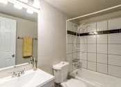 Thumbnail 11 of 30 - A white bathroom with a toilet, sink, and bathtub.