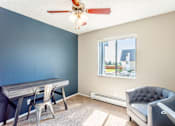Thumbnail 18 of 30 - A room with a blue wall and a ceiling fan.
