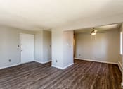 Thumbnail 9 of 30 - A room with wooden floors and white walls.