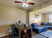 Thumbnail 13 of 30 - A dining room with a table set for two and a blue couch.