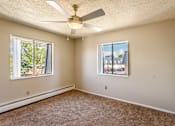 Thumbnail 10 of 30 - A room with a ceiling fan and two windows.