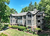 Thumbnail 13 of 27 - the view of an apartment building with a lawn and trees