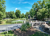 Thumbnail 5 of 27 - a park with a pond and a bridge