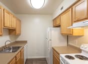 Thumbnail 20 of 30 - a kitchen with wood cabinets and white appliances