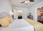 Thumbnail 22 of 31 - A bedroom with a bed, dresser, and ceiling fan.