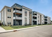 Thumbnail 14 of 31 - A row of modern apartment buildings with balconies and doors.