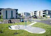 Thumbnail 23 of 31 - A playground with a blue pole and a white fence.