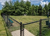 Thumbnail 24 of 31 - A black chain link fence surrounds a green park bench.