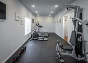 Thumbnail 12 of 31 - A well-equipped home gym with a variety of exercise machines.