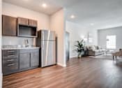 Thumbnail 20 of 31 - A modern kitchen with dark wood floors and stainless steel appliances.
