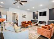 Thumbnail 18 of 31 - A living room with a fireplace, a television, and a sofa.