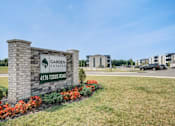 Thumbnail 7 of 31 - A sign for Garden Estates at 4176 Todds Road stands in front of a building.