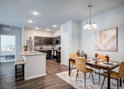 Thumbnail 3 of 31 - A modern kitchen with a dining table set for four.