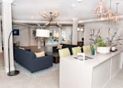 Thumbnail 17 of 33 - A modern living room with a dark blue sofa and a white kitchen island.