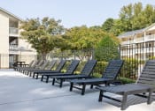 Thumbnail 13 of 19 - a row of lounge chairs in front of an apartment building